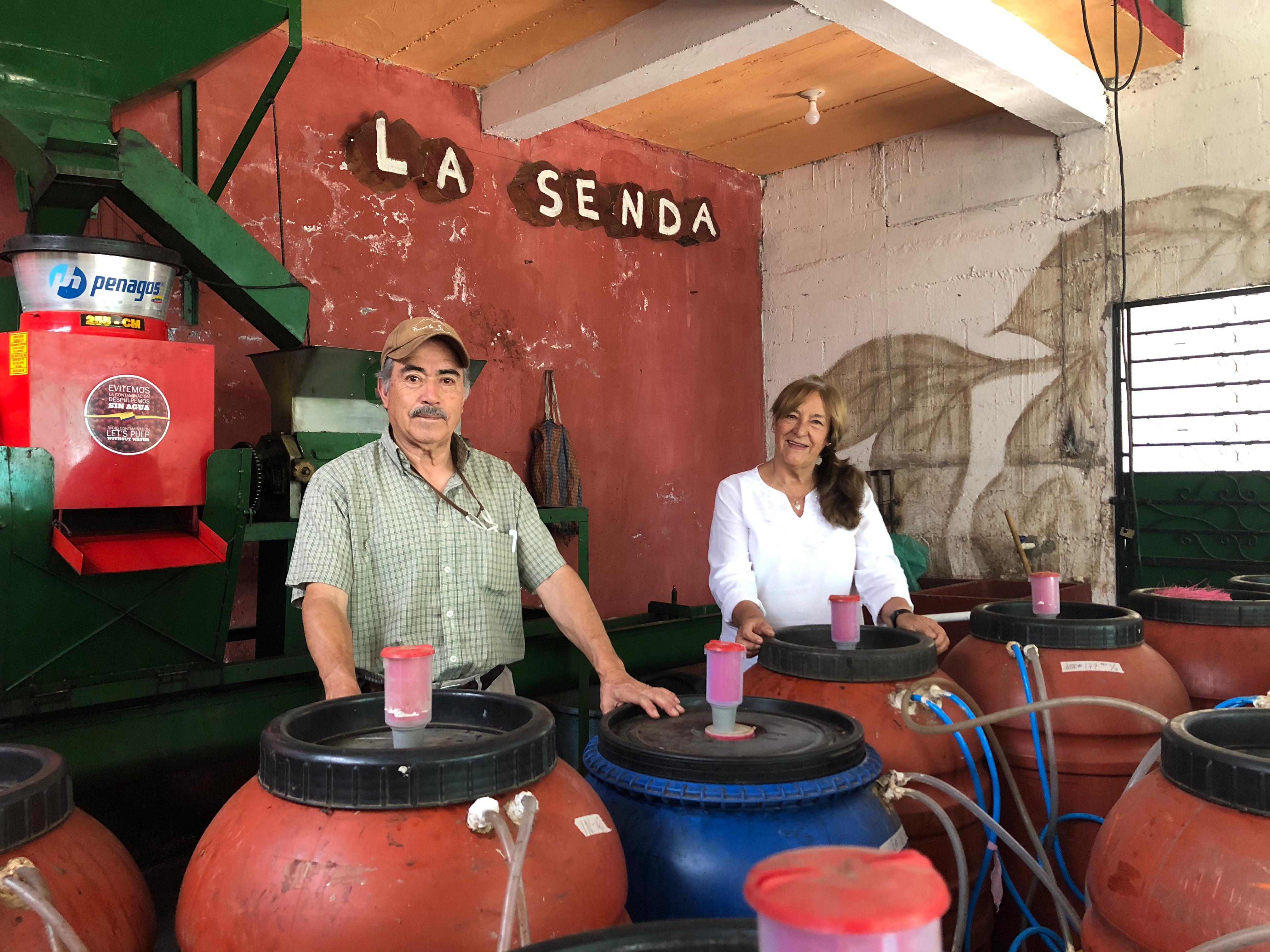 Farmers Maria Eugenia and Jose Arnoldo Perez stand in front of their anaerobic tanks